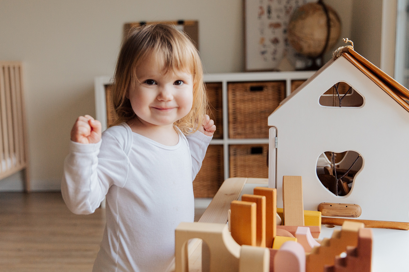 A toddler proudly playing with toys