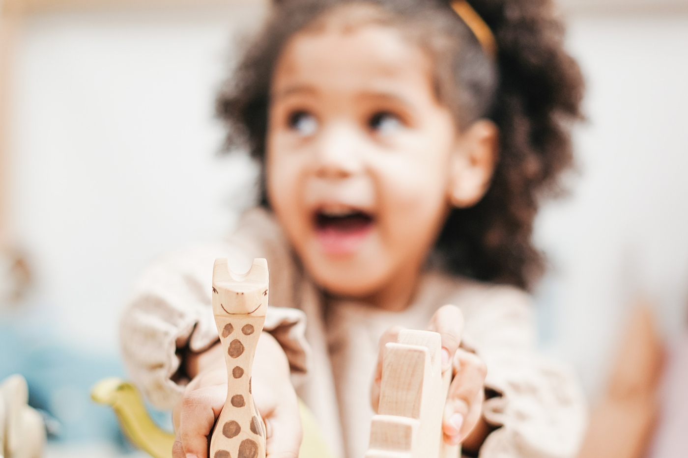 A toddler proudly playing with toys