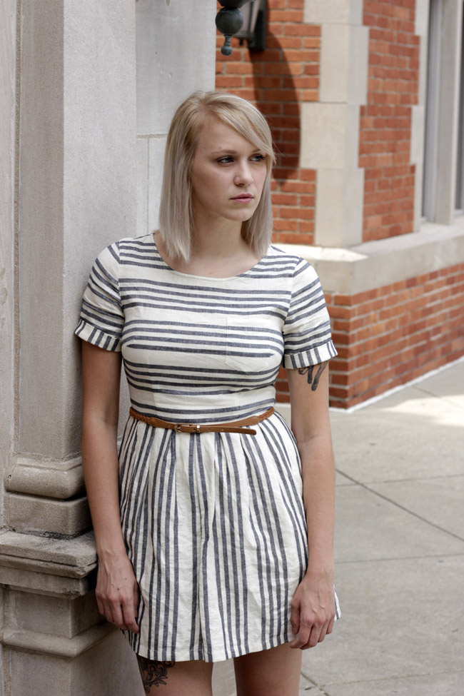 Alexis leaning against building
