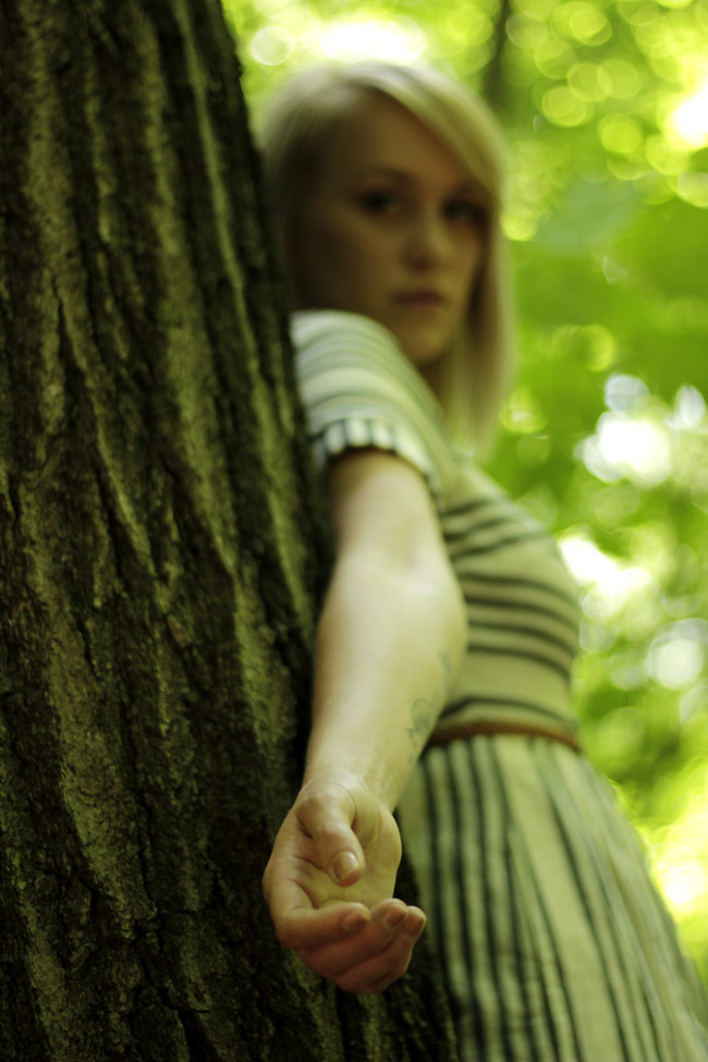Alexis leaning on tree